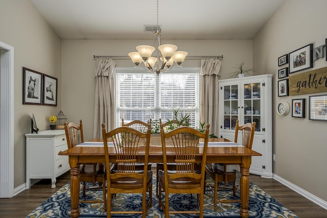 dining space featuring dark wood-style floors, baseboards, visible vents, and a chandelier