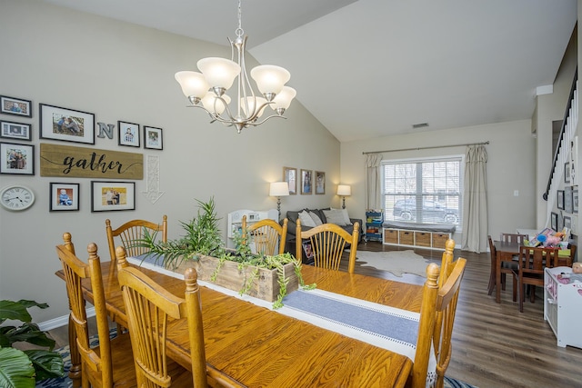 dining area featuring baseboards, visible vents, wood finished floors, vaulted ceiling, and a notable chandelier