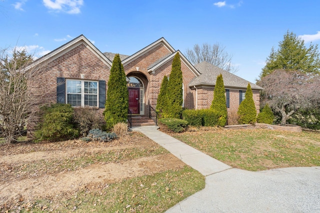 view of front of property featuring brick siding and a shingled roof