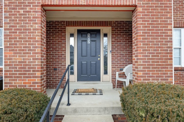 view of exterior entry featuring brick siding