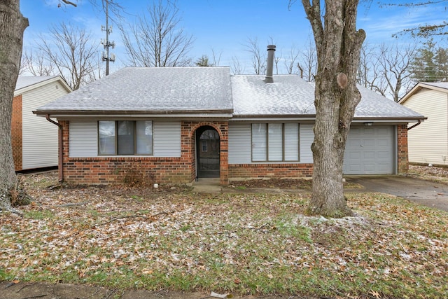 ranch-style home featuring concrete driveway, brick siding, roof with shingles, and an attached garage