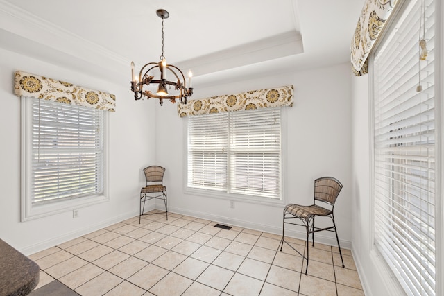 unfurnished room with a raised ceiling, a notable chandelier, ornamental molding, light tile patterned flooring, and baseboards