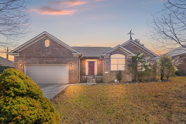 single story home featuring concrete driveway, an attached garage, brick siding, and a yard