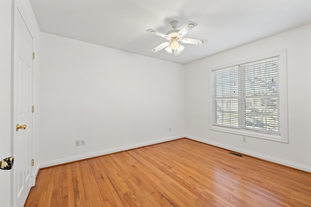 unfurnished room featuring visible vents, light wood-style flooring, a ceiling fan, and baseboards