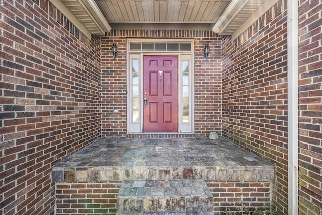 doorway to property featuring brick siding