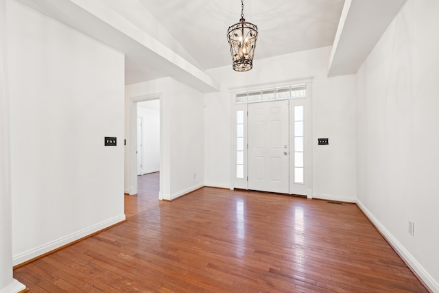 foyer entrance with baseboards, wood-type flooring, and a notable chandelier