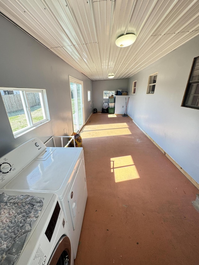 washroom featuring wood ceiling, washing machine and clothes dryer, and laundry area