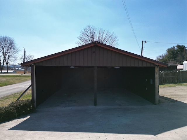 garage with fence and a detached carport