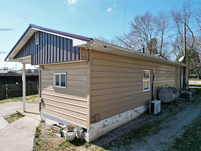 view of side of home featuring crawl space, heating fuel, fence, and central AC