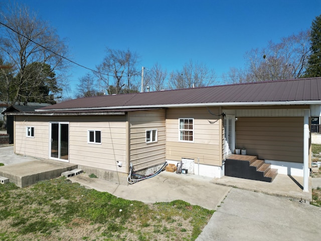 rear view of property featuring metal roof and a patio