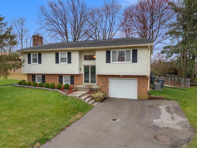 raised ranch with brick siding, a chimney, a front yard, and fence