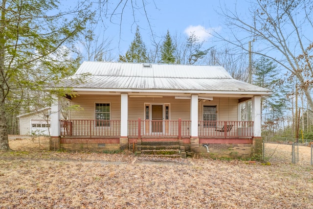 view of front of house with crawl space, a porch, metal roof, and fence