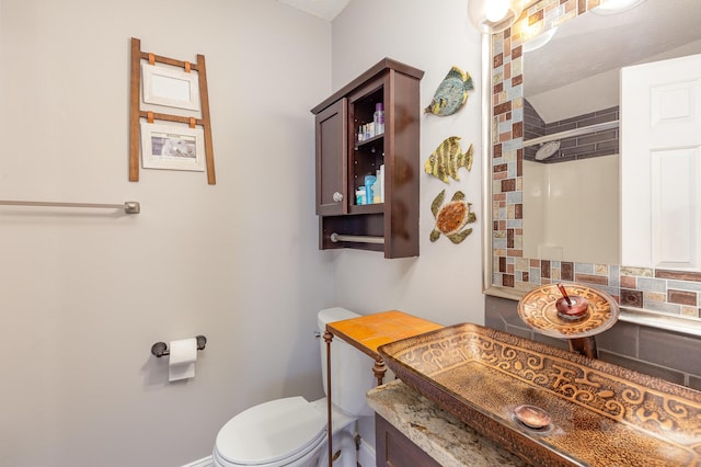 bathroom featuring backsplash, vanity, and toilet