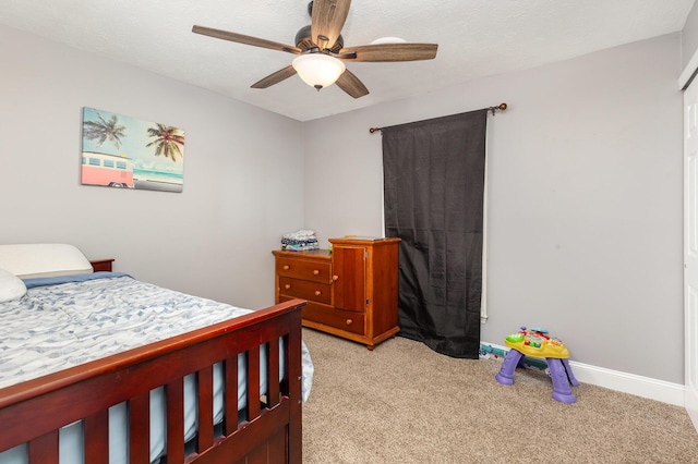 bedroom with light carpet, a textured ceiling, a ceiling fan, and baseboards