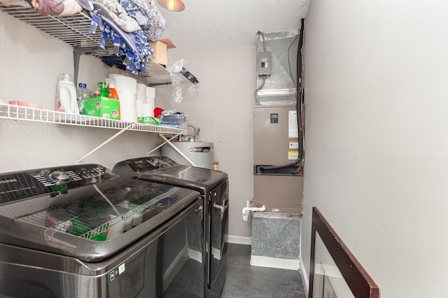 laundry room featuring laundry area, water heater, washer and clothes dryer, and baseboards