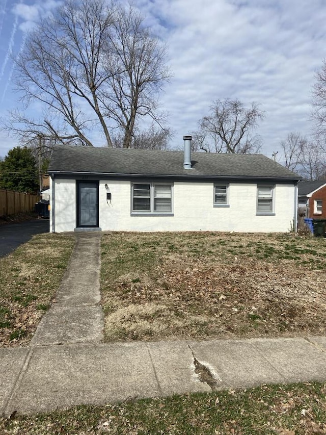 view of front of property with roof with shingles and fence