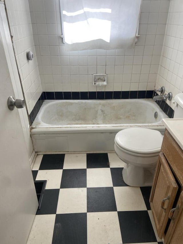 bathroom featuring tile patterned floors, toilet, vanity, and shower / tub combination