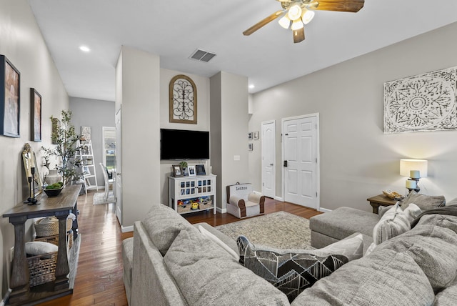 living area with visible vents, baseboards, a ceiling fan, and hardwood / wood-style flooring