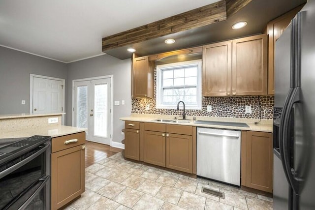 kitchen featuring tasteful backsplash, visible vents, light countertops, black appliances, and a sink