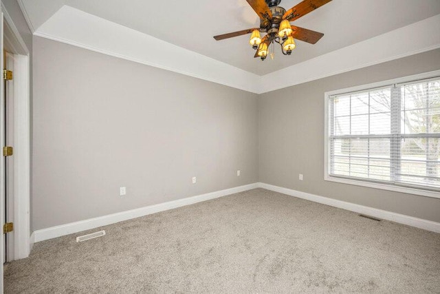 carpeted empty room with a ceiling fan, visible vents, and baseboards