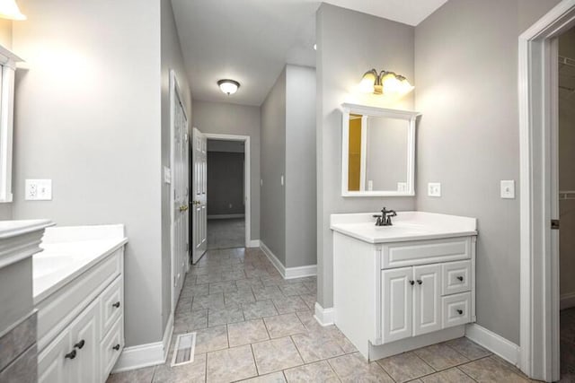 bathroom featuring a sink, visible vents, baseboards, and two vanities