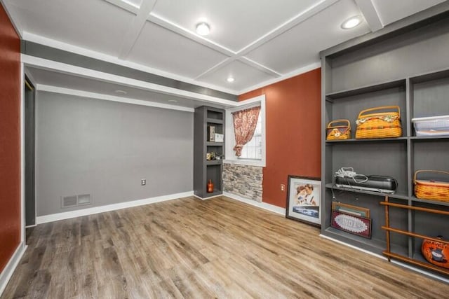 unfurnished room with coffered ceiling, visible vents, baseboards, and wood finished floors