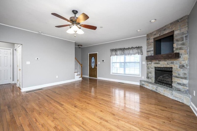 unfurnished living room with a fireplace, wood finished floors, a ceiling fan, baseboards, and stairway