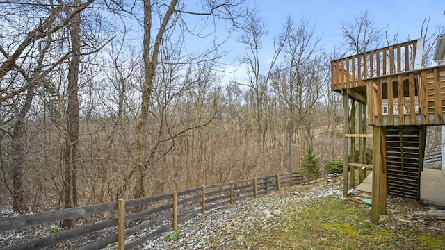 view of yard featuring stairs, a wooded view, fence, and a wooden deck