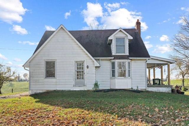 view of front of house featuring a shingled roof, a porch, a chimney, and a front lawn