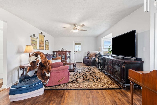 living room featuring a textured ceiling, a ceiling fan, and wood finished floors