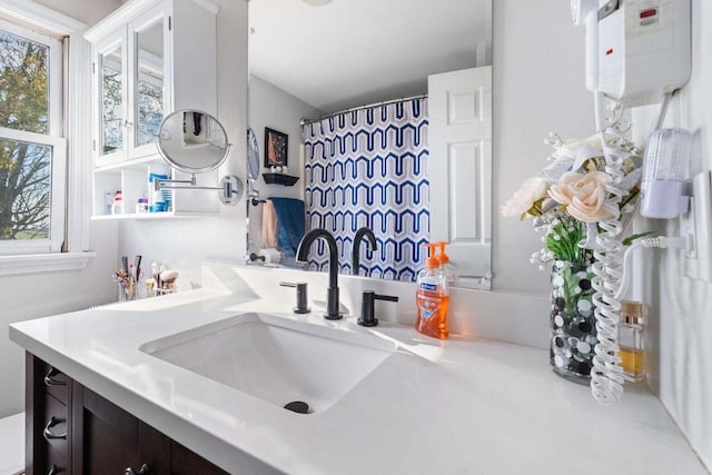 bathroom with curtained shower, water heater, and vanity