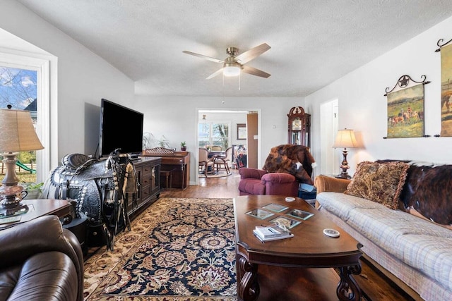 living room featuring a textured ceiling, wood finished floors, and a ceiling fan