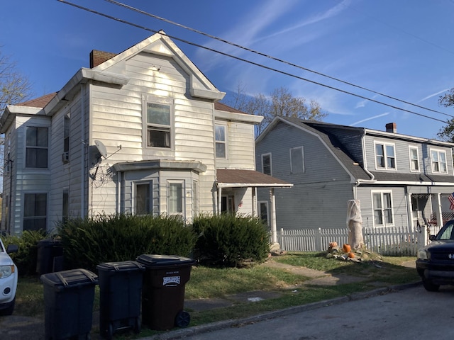 view of front of house with a shingled roof and fence