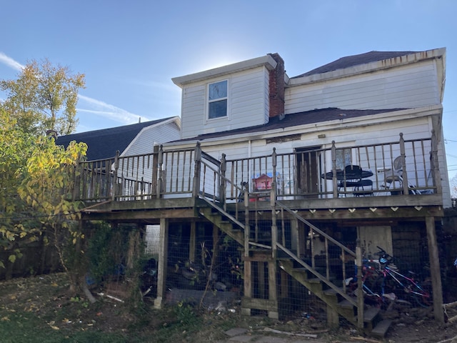 rear view of property featuring stairs and a wooden deck