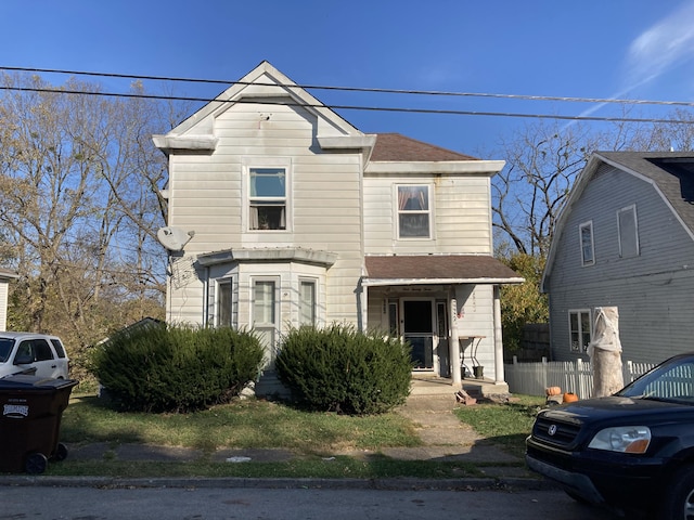 view of front of home with roof with shingles and fence