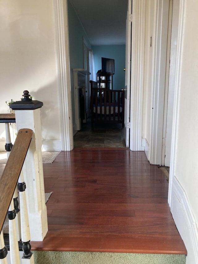 hallway featuring an upstairs landing and wood finished floors