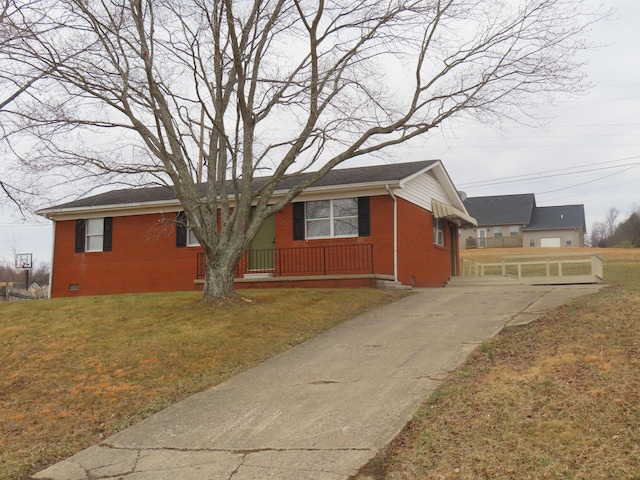 view of side of home featuring crawl space, brick siding, and a lawn