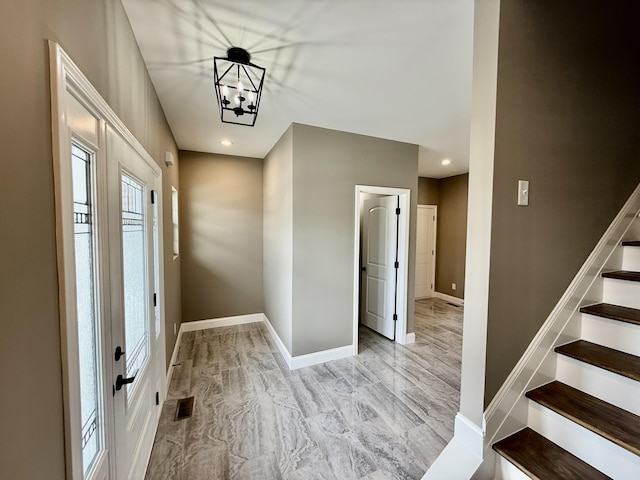 foyer entrance with visible vents, baseboards, stairway, recessed lighting, and an inviting chandelier