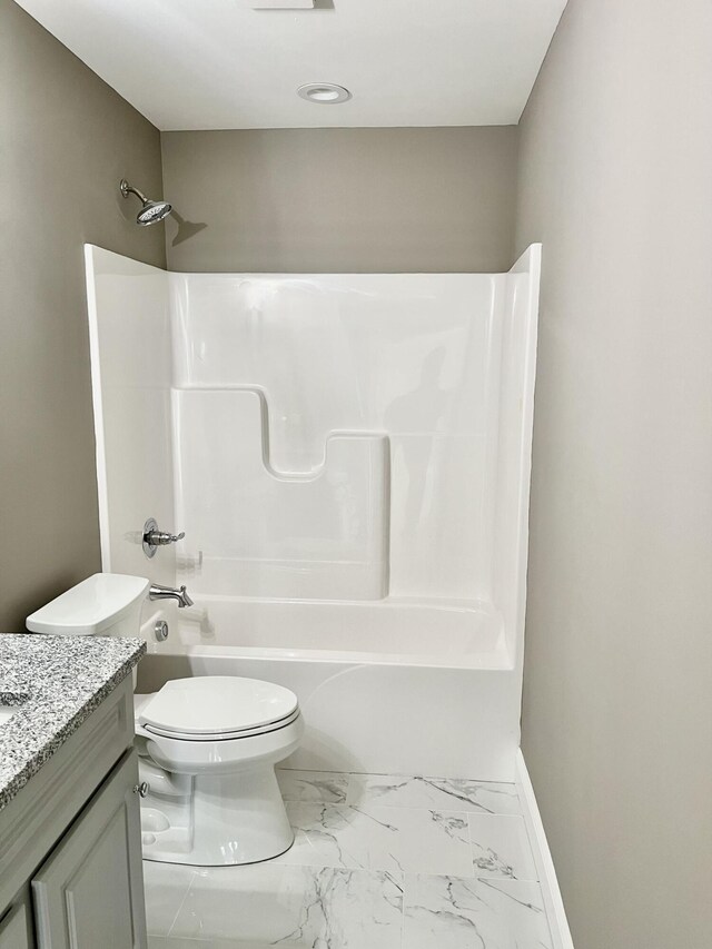 bathroom featuring toilet, marble finish floor, shower / bath combination, baseboards, and vanity