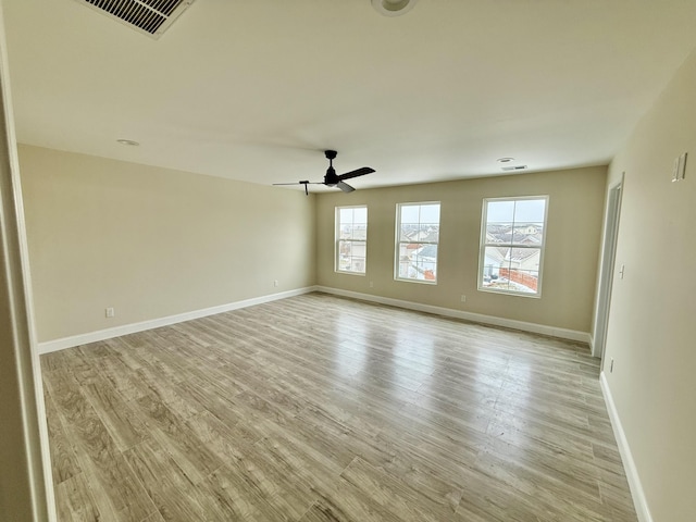 empty room with ceiling fan, baseboards, visible vents, and light wood-type flooring