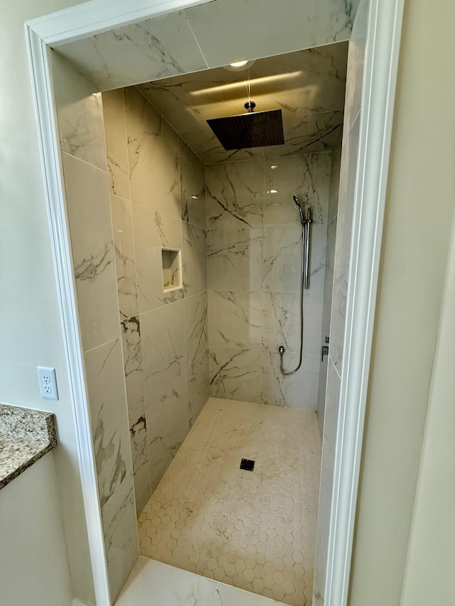 bathroom featuring a marble finish shower