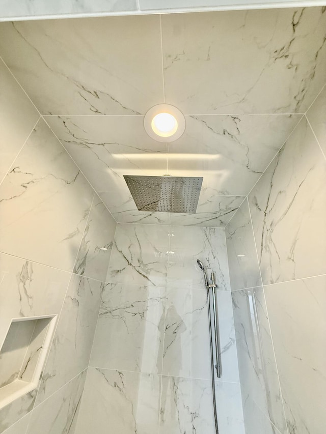 details with a marble finish shower and visible vents