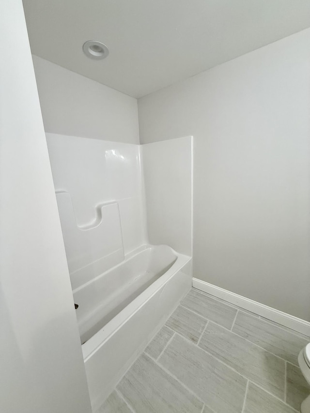 bathroom with baseboards and toilet