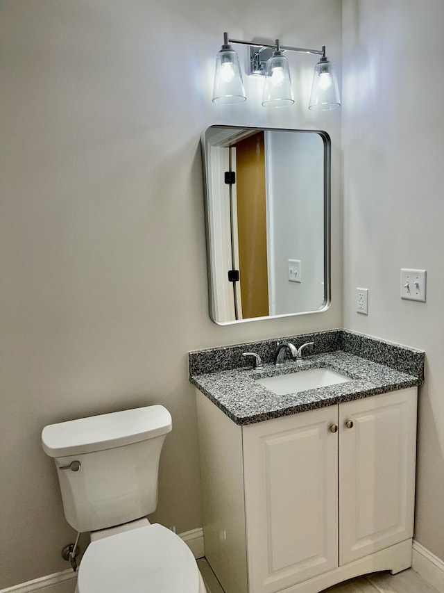 bathroom featuring vanity, toilet, and baseboards