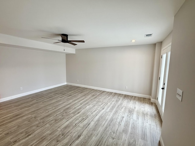 unfurnished room with a ceiling fan, visible vents, wood finished floors, baseboards, and a healthy amount of sunlight