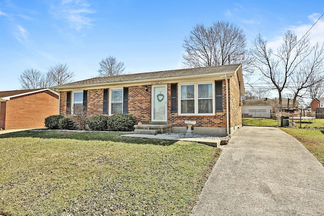 ranch-style home with brick siding, a front lawn, and fence