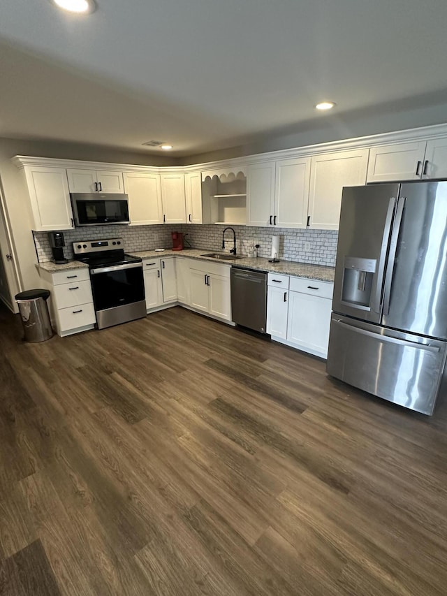 kitchen featuring stainless steel appliances, a sink, and white cabinetry