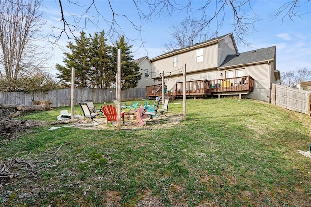 view of yard featuring a fire pit, a fenced backyard, and a wooden deck