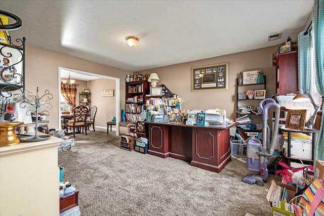 home office featuring a textured ceiling, visible vents, carpet floors, and a chandelier