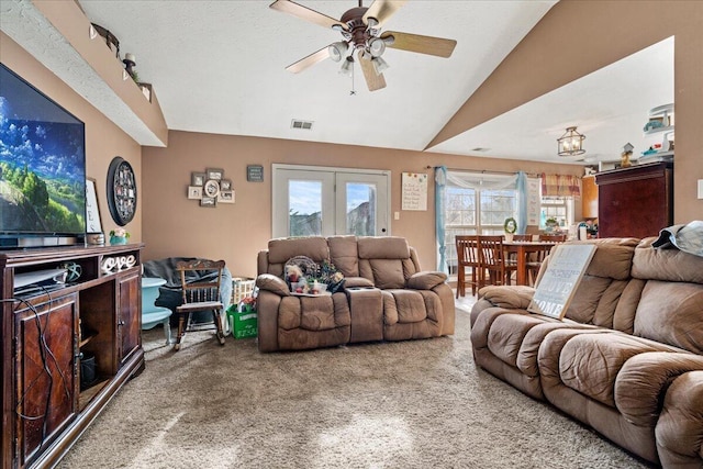 carpeted living room with visible vents, ceiling fan, and vaulted ceiling